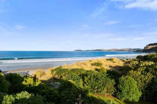 a view of a beach with the ocean in the background at Karitane Beach Retreat - Karitane Holiday Home in Karitane