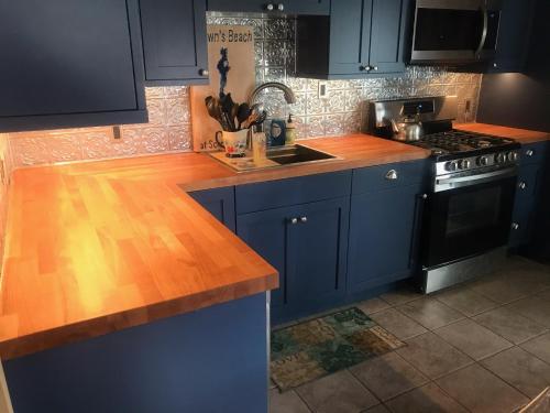 a kitchen with blue cabinets and a wooden counter top at Brown's Beach at Schroon Lake in Schroon Lake