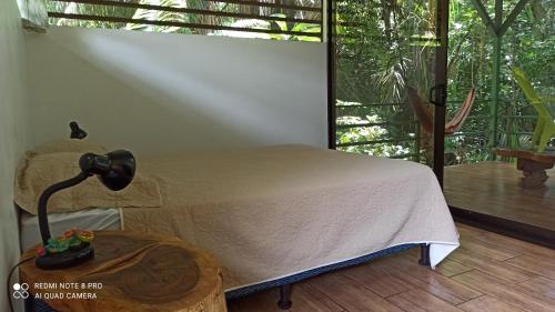 1 dormitorio con 1 cama y 1 mesa con lámpara en Selva Linda Lodge vacation rentals, en Quepos