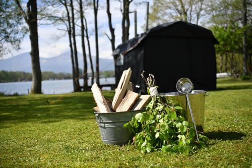 a bucket of wood and a plant in the grass at Lakeside Hotels Kuore in Kitashiobara