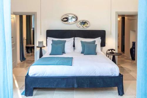 a bedroom with a large bed with blue pillows at Borgo dei Lecci Puglia in Selva di Fasano