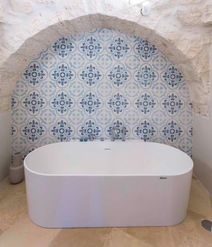 a white toilet in a bathroom with a wall at Borgo dei Lecci Puglia in Selva di Fasano