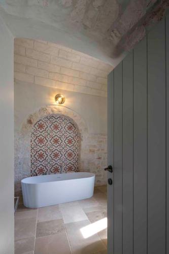 a bathroom with a bath tub in a room at Borgo dei Lecci Puglia in Selva di Fasano