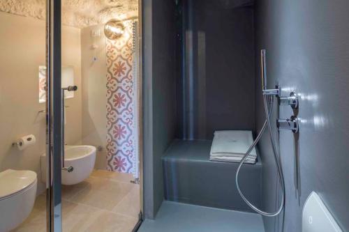a bathroom with a shower with a toilet and a sink at Borgo dei Lecci Puglia in Selva di Fasano