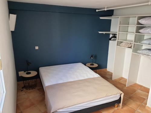 une chambre avec un lit et un mur bleu dans l'établissement Appartement avec parking privatif à Collioure, à Collioure
