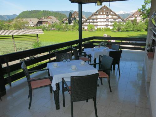 um restaurante com mesas e cadeiras na varanda em Guest House Golja em Bled