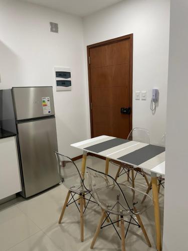 uma mesa e cadeiras numa cozinha com um frigorífico em Asuncion Gracia Suites em Assunção