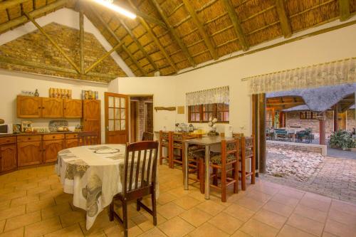 a kitchen and dining room with a table and chairs at SERENITY Du Bois Lodge in Marloth Park