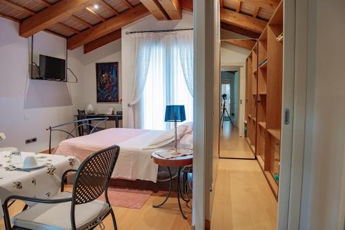 RosàにあるRosa del Grappaのベッドルーム1室(ベッド1台、テーブル、椅子付)