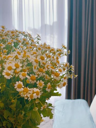 a large vase filled with yellow and white flowers at Qhome in Ho Chi Minh City