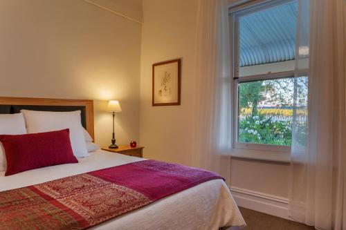 a bedroom with a bed and a large window at Basedow Haus in Tanunda