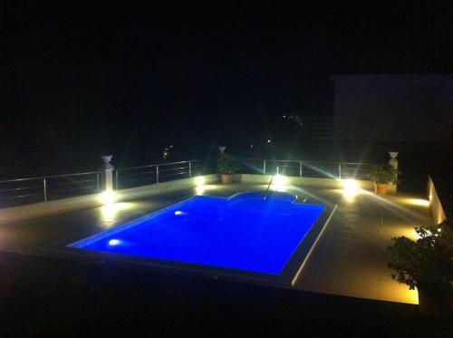a swimming pool lit up at night with lights at Villa Pincevic in Lopud Island