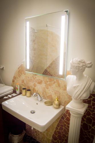 a bathroom with a sink and a statue of a woman at Hotel Bojnický vínny dom in Bojnice