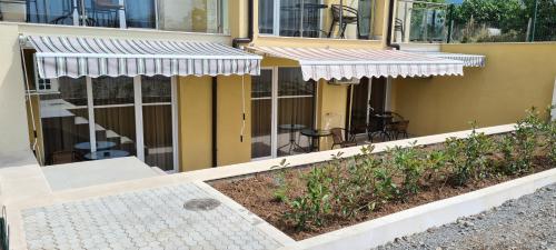 a house with two awnings and a patio at Семеен хотел Сирена in Ahtopol