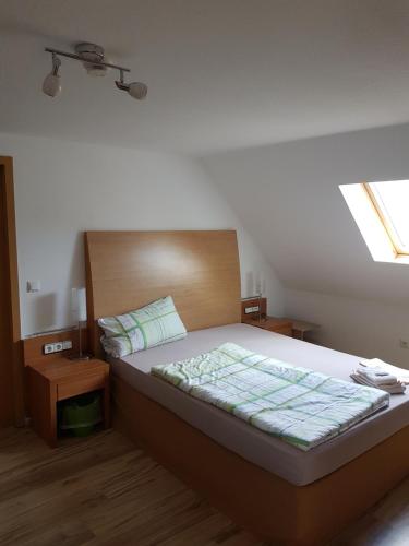 a bedroom with a bed with a wooden headboard at Pension Zur Eiche in Drebenstedt