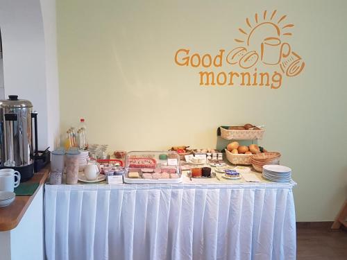 ein Tisch mit Essen darauf und einem Guten-Morgen-Schild darauf in der Unterkunft Pension Zur Eiche in Drebenstedt