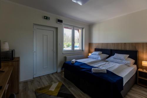 een slaapkamer met een groot bed en een raam bij Tulip Garden Panzió in Kékcse