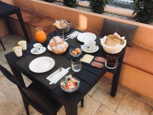 - une table noire avec de la nourriture pour le petit-déjeuner dans l'établissement B&B De Janas, à La Caletta