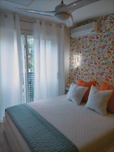 a bedroom with a bed with a floral wall at Vila LYDIA in Cambrils