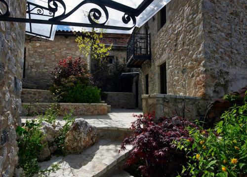 a stone building with a courtyard with flowers and plants at Villa Vager in Levidhion