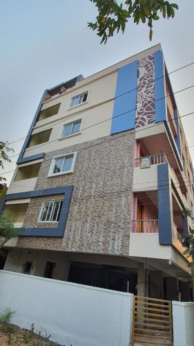 a tall building with blue windows and stairs on it at Tirupati Homestay - 2BHK AC Family Apartments near Alipiri and Kapilatheertham - Walk to A2B Veg Restaurant - WiFi - Android TV - Easy access to Tirumala in Tirupati