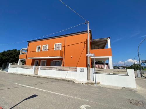 an orange building on the side of a street at Nure in Stintino