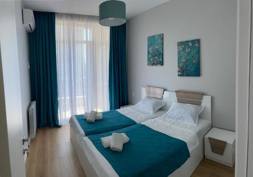 two beds in a room with blue and white at Maia's Sweet Homes in Batumi