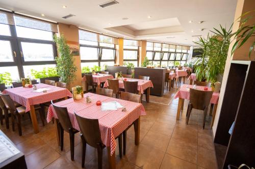 a restaurant with tables and chairs and windows at Penzion Toscana in Nitra