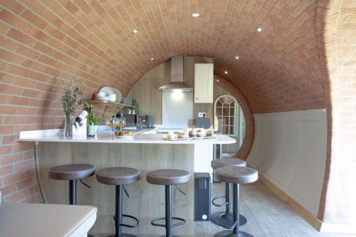 a kitchen with a counter and stools in a room at Wabbit, The Little Burrow, Radstock in Radstock