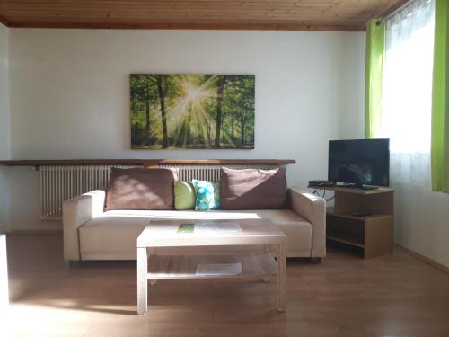 Komfortzimmer Haus Dervaritz في Einöd: غرفة معيشة مع أريكة وطاولة قهوة