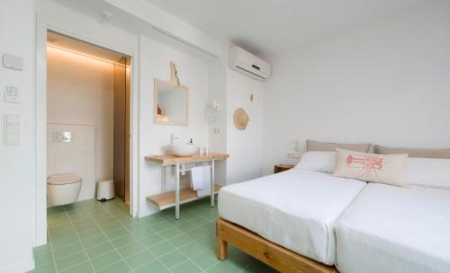 a bedroom with a bed and a bathroom with a sink at Hostal Boutique Cana Rita in San Antonio