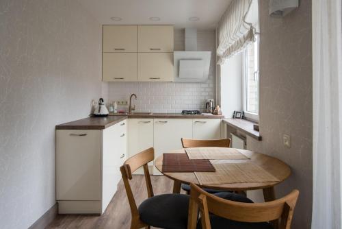 eine kleine Küche mit einem Holztisch sowie einem Tisch und Stühlen in der Unterkunft Cosy Scandi Home near the Old Town. Self Check-In in Klaipėda