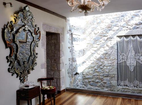 a room with a stone wall with a mirror and a chandelier at Villa Vager in Levidhion