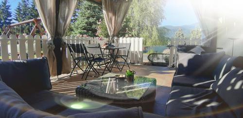 a patio with chairs and a table and a fence at Apartment Sabljaci by the Lake in Ogulin