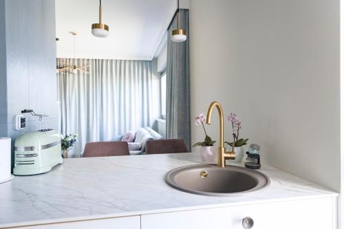 a kitchen counter with a sink and a living room at Aqua Your Stay in Sasino