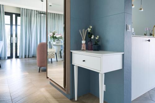 a bathroom with a white dressing table and a mirror at Aqua Your Stay in Sasino