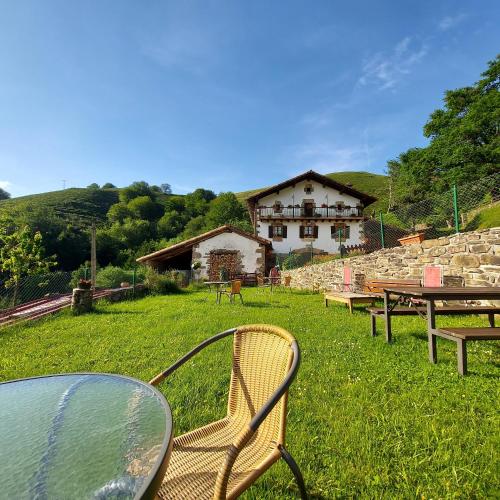 a table and chairs in a yard with a building at CASA RURAL Urruska in Elizondo