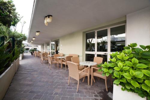 a row of tables and chairs on a patio at Hotel Plaza in Rimini