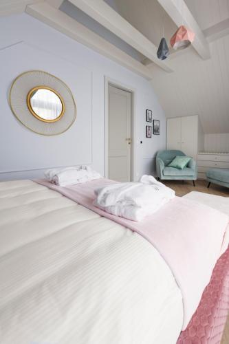 a bedroom with a large white bed with a mirror on the wall at Aqua Your Stay in Sasino