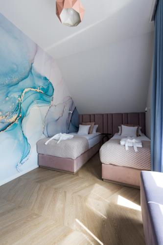 a bedroom with two beds and a mural at Aqua Your Stay in Sasino