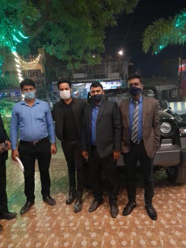 a group of men wearing masks in front of a car at Hotel Radiance Courtyard in Varanasi