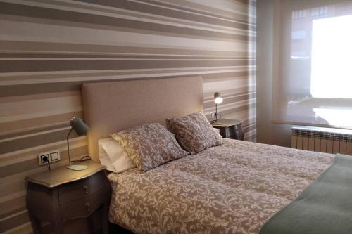 a bedroom with a bed and two lamps and a window at LA TERRAZA DE LA FLORIDA terraza 225 m2 in Oviedo