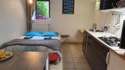 a small room with a small bed in a kitchen at les floralis studio in La Grée-Saint-Laurent
