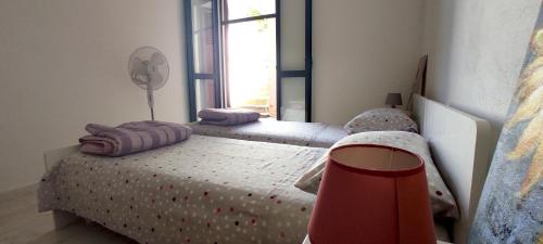 a bedroom with two twin beds and a window at La Dolce Vista in Magomadas