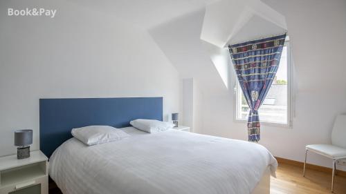 um quarto com uma cama branca e uma janela em La Traversée em Frehel