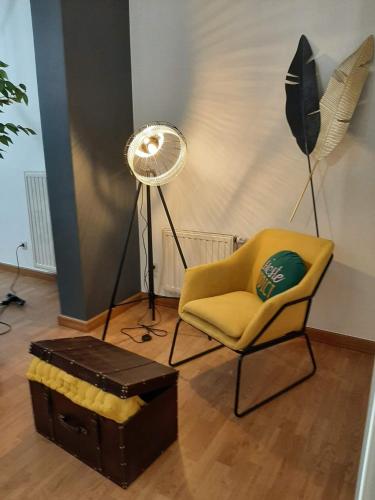 a living room with a chair and a fan at Appartement centre de Dinant in Dinant