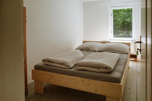 a bed with four pillows on it in a room at Dom na Slivnici in Cerknica