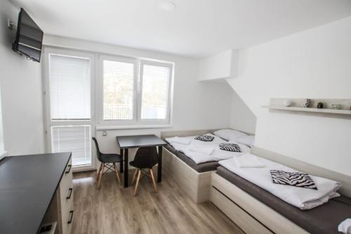 a room with two beds and a table at Hotel U Pláže in Vranov nad Dyjí