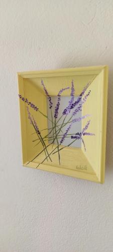 a box with a painting of purple flowers on a wall at Sea breeze Apartments with boat Anchorage in Stara Novalja