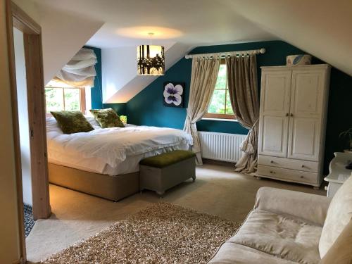 1 dormitorio con paredes azules, 1 cama y 1 sofá en The Vandees en Aghalee